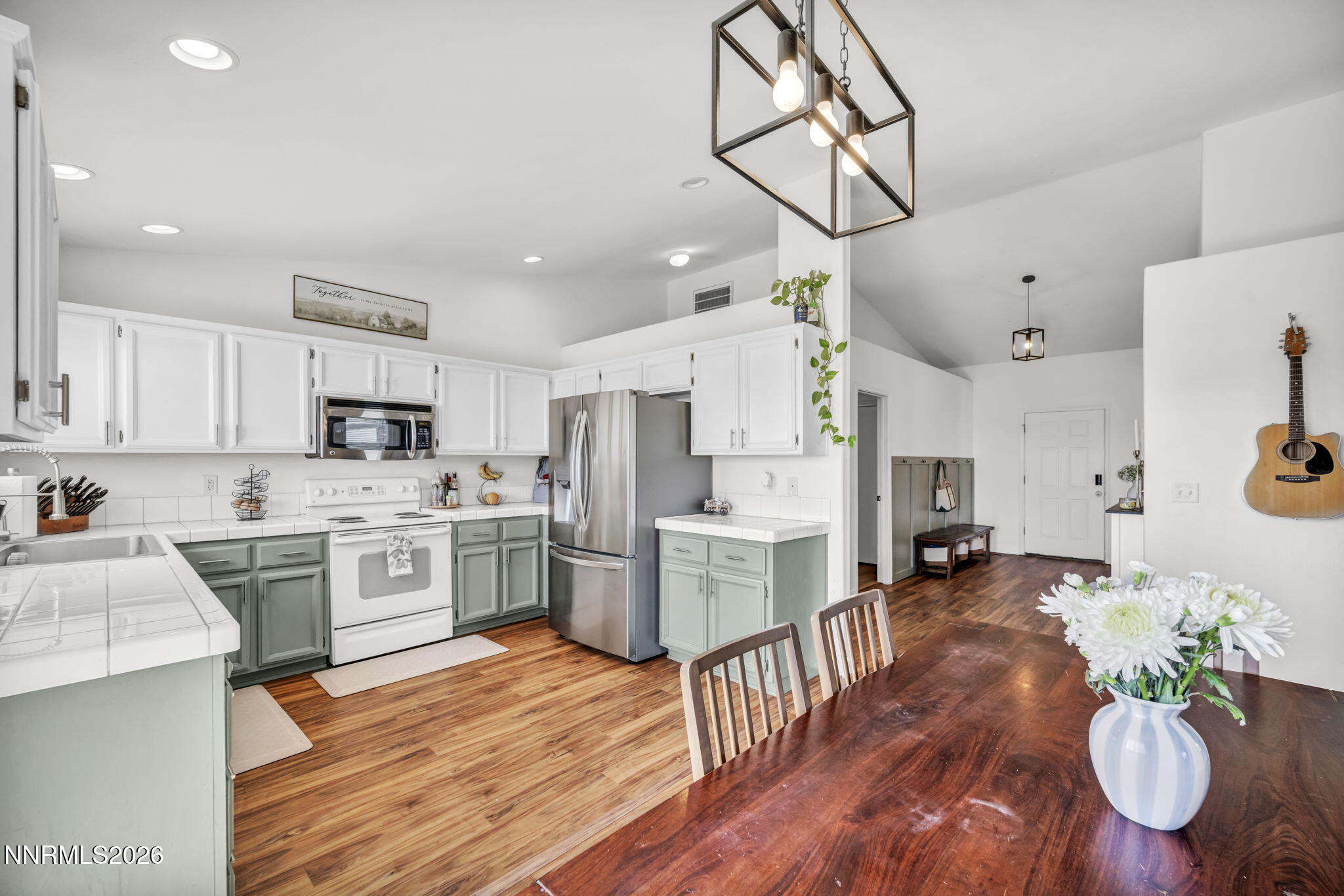 111 Relief Springs Road Fernley, NV 89408 - Photo 8 of 30 a kitchen with stainless steel appliances kitchen island granite countertop a stove a refrigerator a oven a sink a dining table and chairs with wooden floor
