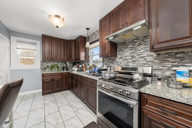 a kitchen with stainless steel appliances granite countertop a stove sink and cabinets