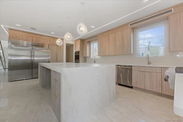 a large kitchen with stainless steel appliances granite countertop a sink and cabinets
