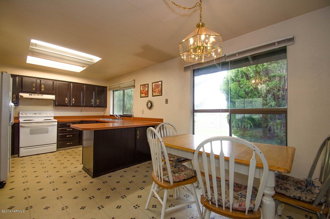 12605 Douglas Road Yakima, WA 98908 - Photo 3 of 10 a kitchen with stainless steel appliances granite countertop a stove top oven a sink a dining table and chairs