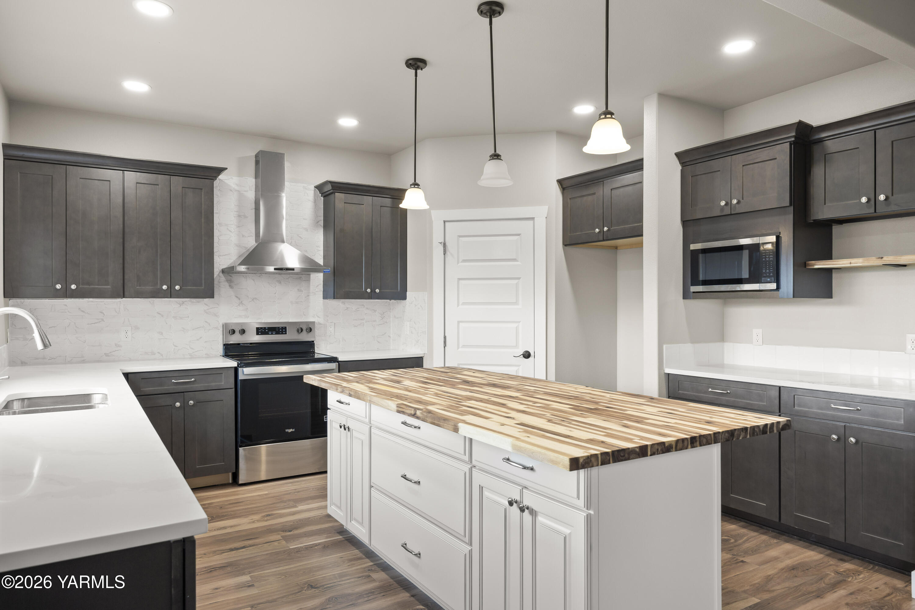 6133 South Moore Road Prosser, WA 99350 - Photo 13 of 54 a kitchen with a stove a refrigerator a sink and a wooden floor