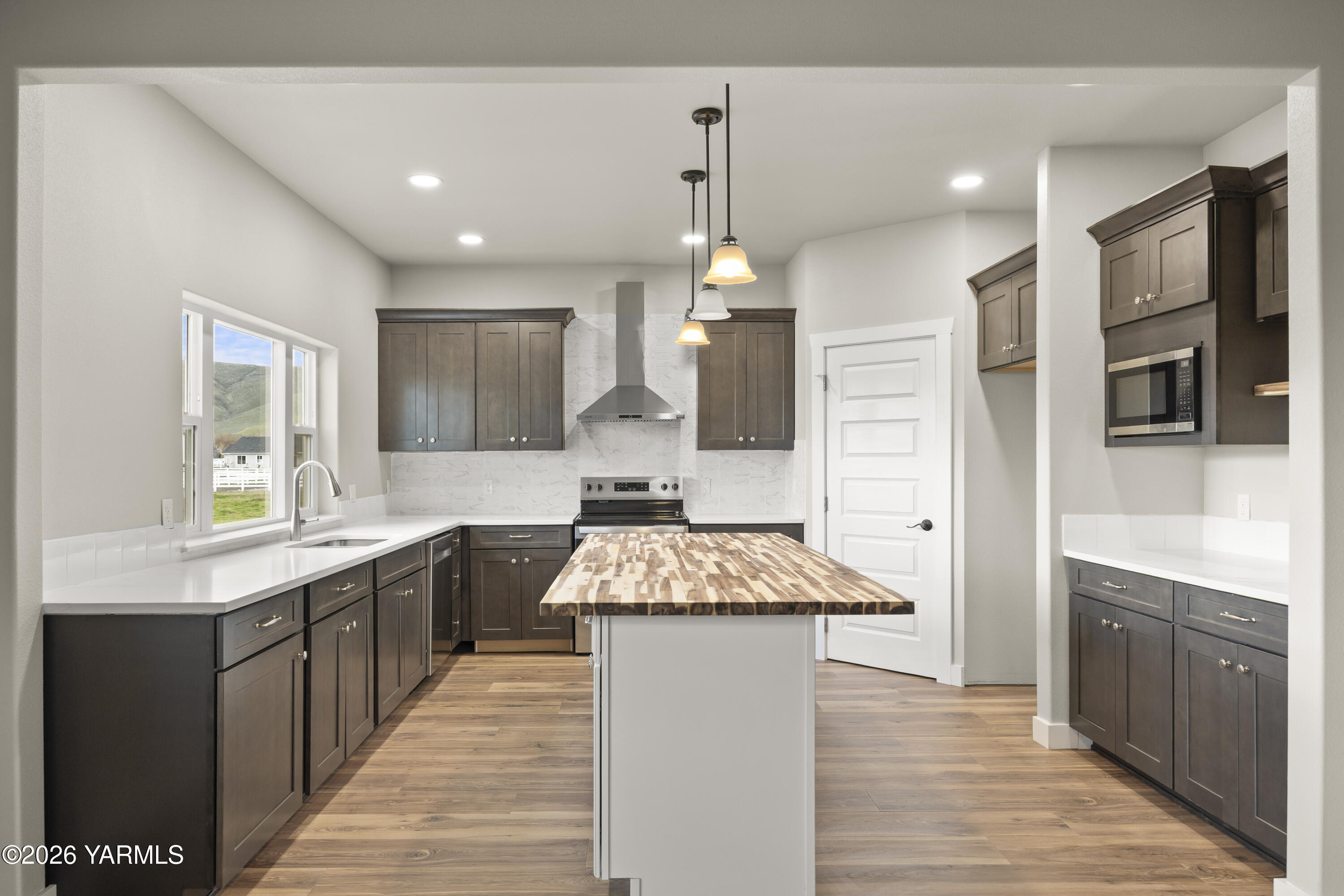 6133 South Moore Road Prosser, WA 99350 - Photo 14 of 54 a large kitchen with stainless steel appliances granite countertop a sink stove and refrigerator