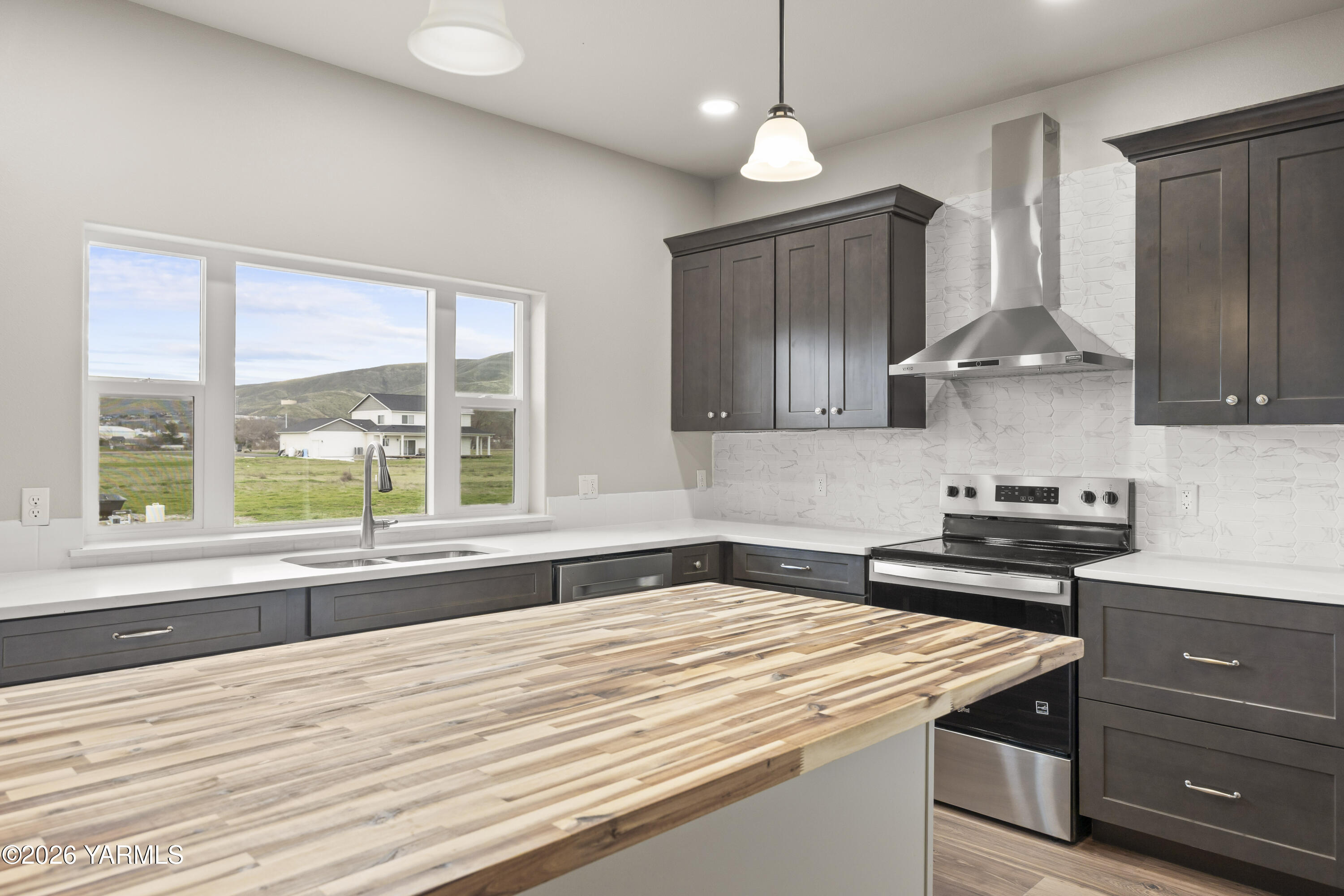 6133 South Moore Road Prosser, WA 99350 - Photo 15 of 54 a kitchen with stainless steel appliances granite countertop a sink a stove and a wooden floors