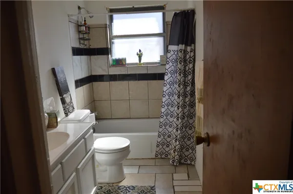 a bathroom with a toilet and a shower curtain