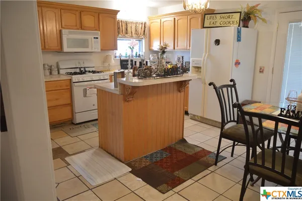 a kitchen with a sink chairs and cabinets
