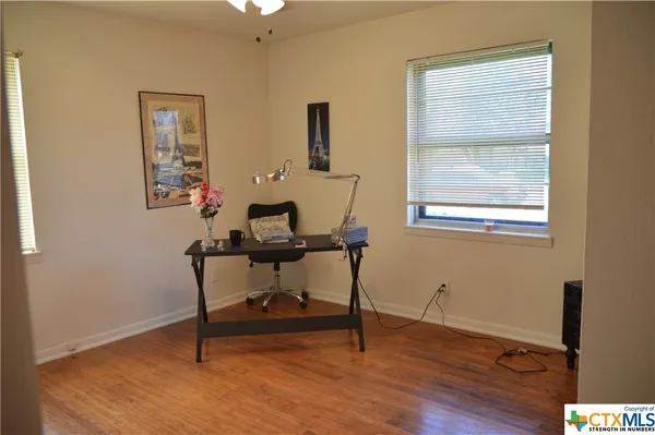 a view of a workspace with furniture and a window