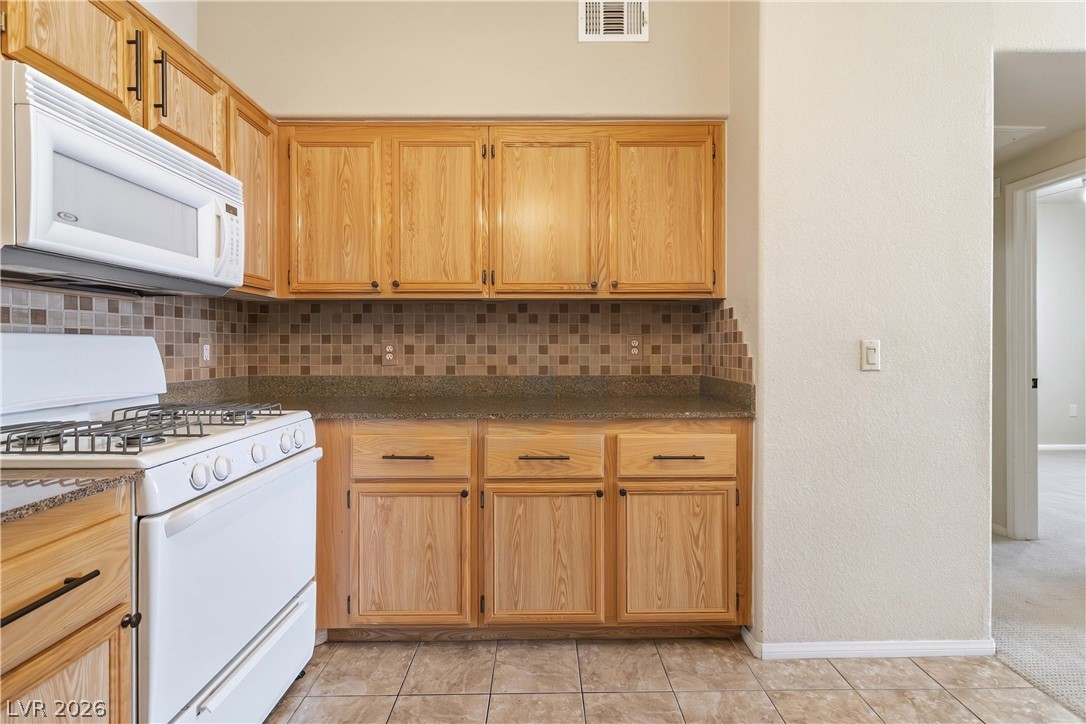 10550 West Alexander Road, Unit 2060 Las Vegas, NV 89129 - Photo 19 of 45 A well-appointed kitchen showcasing durable tile flooring and warm wooden cabinetry.