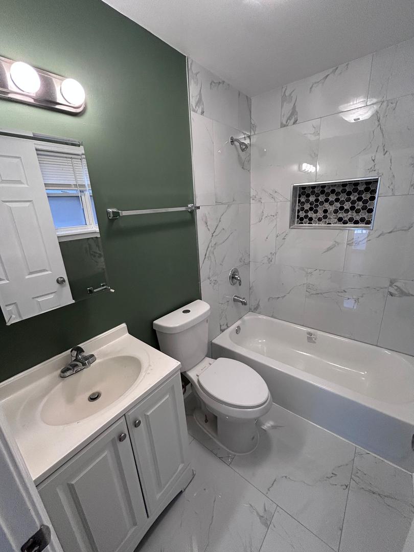 5905 South Indiana Avenue, Unit 1 Chicago, IL 60637 - Photo 8 of 13 a bathroom with a toilet sink and mirror