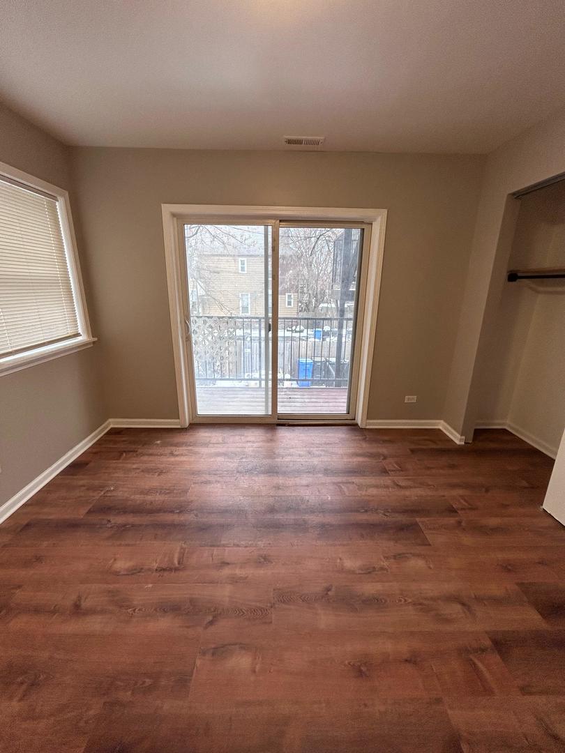 5905 South Indiana Avenue, Unit 1 Chicago, IL 60637 - Photo 9 of 13 an empty room with wooden floor and windows