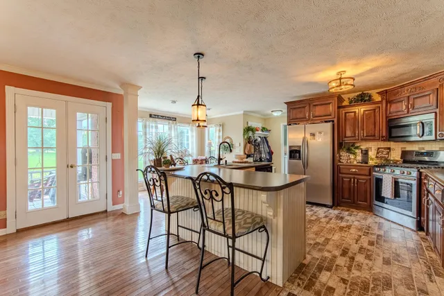 a kitchen with stainless steel appliances granite countertop a refrigerator stove and sink