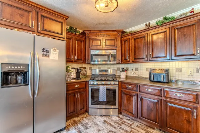 a kitchen with stainless steel appliances granite countertop sink stove and cabinets