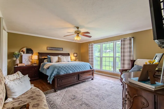 a spacious bedroom with a bed a couch and a chandelier