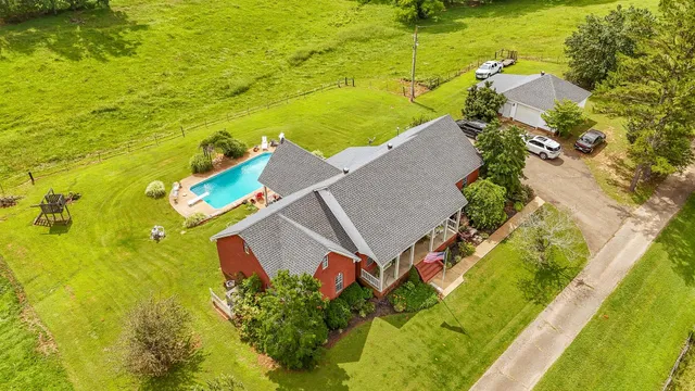 a view of a swimming pool with a yard and plants
