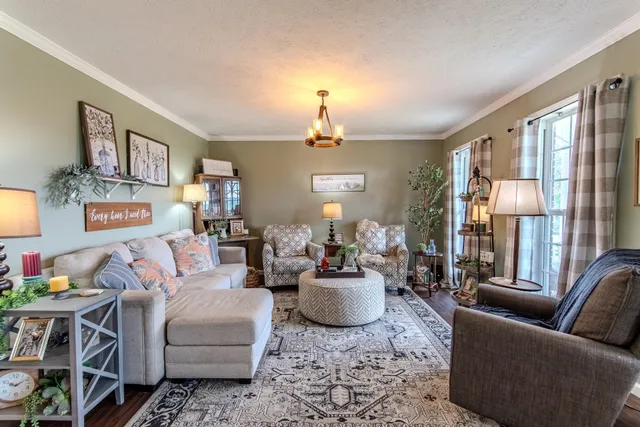 a living room with furniture a chandelier and a window