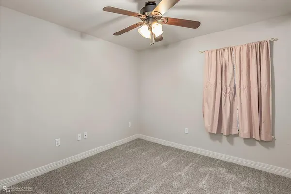an empty room with chandelier fan