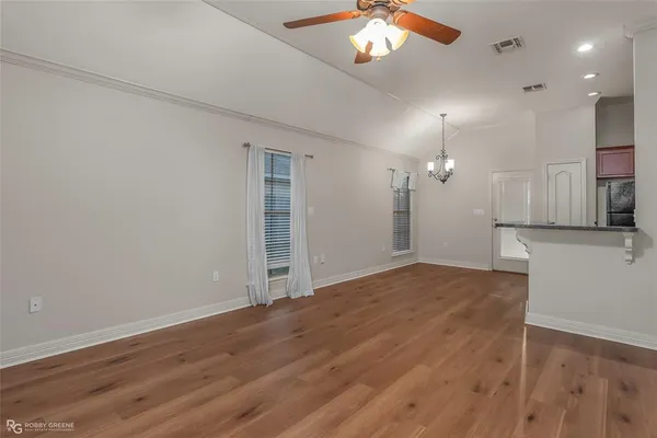an empty room with wooden floor and bathroom