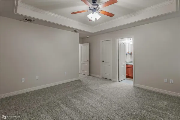 an empty room with closet and a ceiling fan