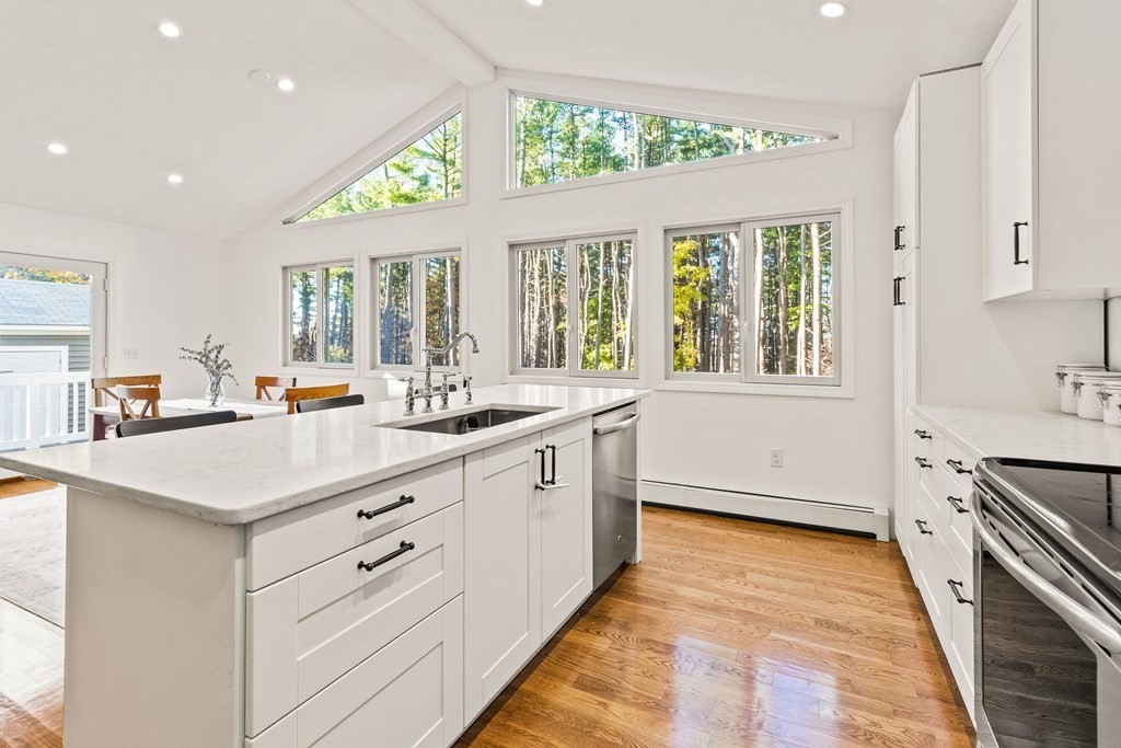21 Bypass Road Lincoln, MA 01773 - Photo 7 of 21 a large white kitchen with granite countertop a sink dishwasher a stove and white cabinets with wooden floor