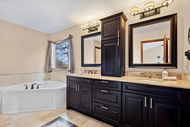 a bathroom with a bathtub sink and mirror