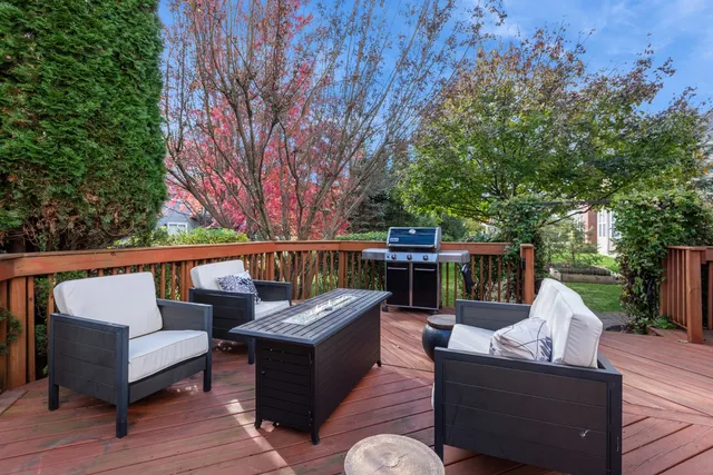 a roof deck with couches and wooden fence