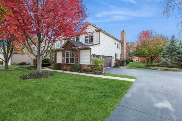 a front view of a house with a yard and trees