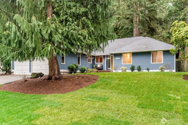 a front view of a house with a garden and yard