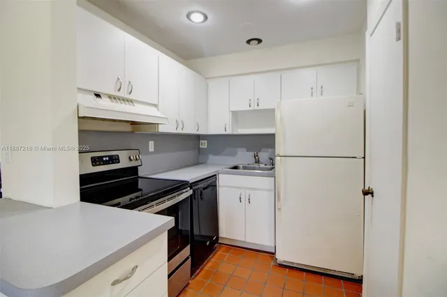 a kitchen with a refrigerator and a stove top oven