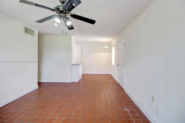wooden floor in an empty room with a chandelier fan