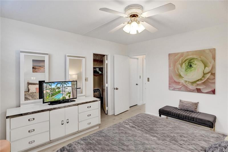 101 North Birch Road, Unit 303 Fort Lauderdale, FL 33304 - Photo 16 of 29 a bedroom with a bed and a chandelier