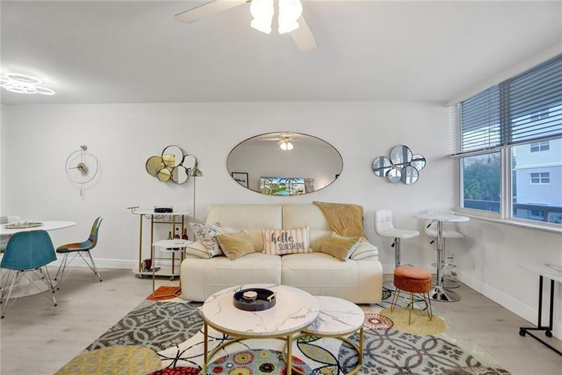 101 North Birch Road, Unit 303 Fort Lauderdale, FL 33304 - Photo 7 of 29 a living room with a couch and a chandelier