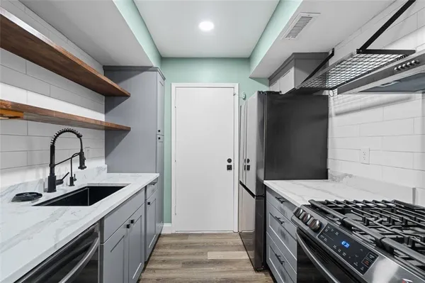 a kitchen with stainless steel appliances granite countertop a sink stove and cabinets