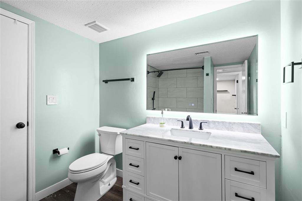 6851 Roswell Road, Unit N10 Atlanta, GA 30328 - Photo 14 of 26 a bathroom with a granite countertop toilet a sink and a mirror