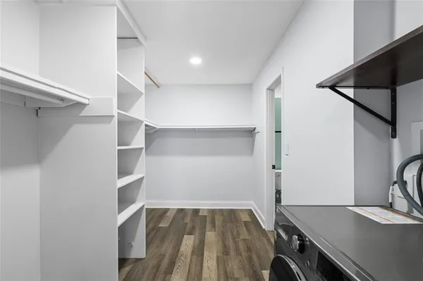 a view of a room with wooden floor and cabinets