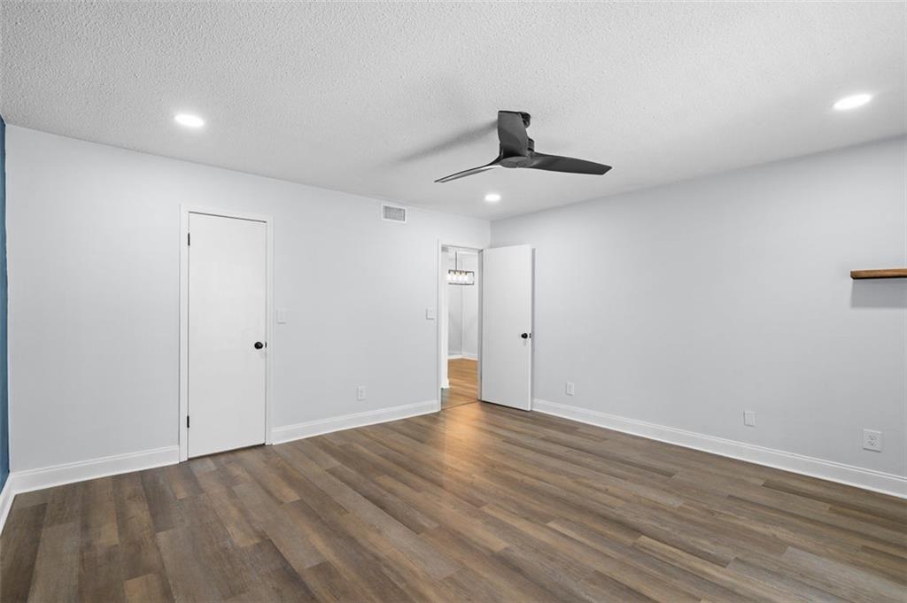 6851 Roswell Road, Unit N10 Atlanta, GA 30328 - Photo 18 of 26 a view of an empty room with wooden floor and ceiling fan