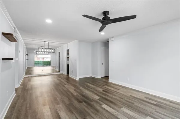 a view of a livingroom with wooden floor and a ceiling fan