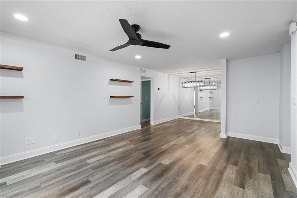 6851 Roswell Road, Unit N10 Atlanta, GA 30328 - Photo 9 of 26 an empty room with wooden floor cabinet and windows