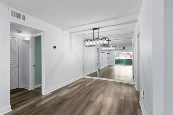 a view of empty room with wooden floor