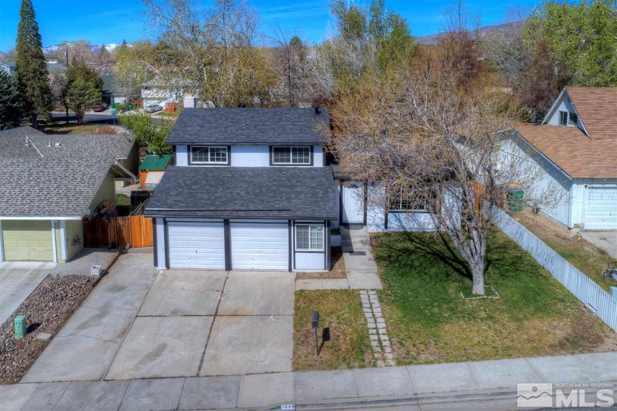 1645 Wyoming Avenue Reno, NV 89503 - Photo 1 of 28 a backyard of a house with large trees and outdoor seating