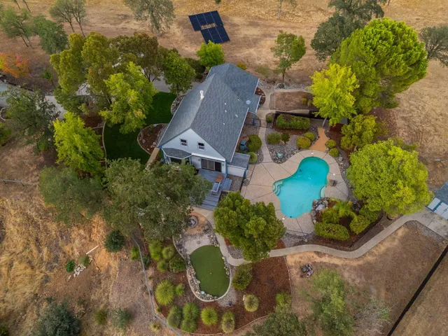 an aerial view of a house with a yard and garden