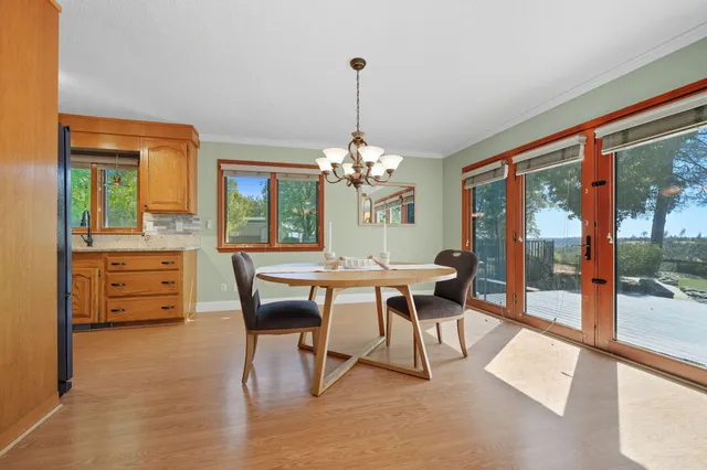 a dining room with furniture a chandelier and wooden floor
