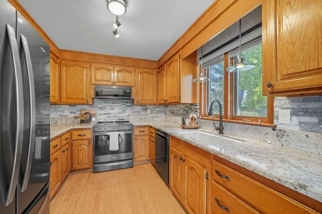 a kitchen with stainless steel appliances granite countertop a sink stove and cabinets