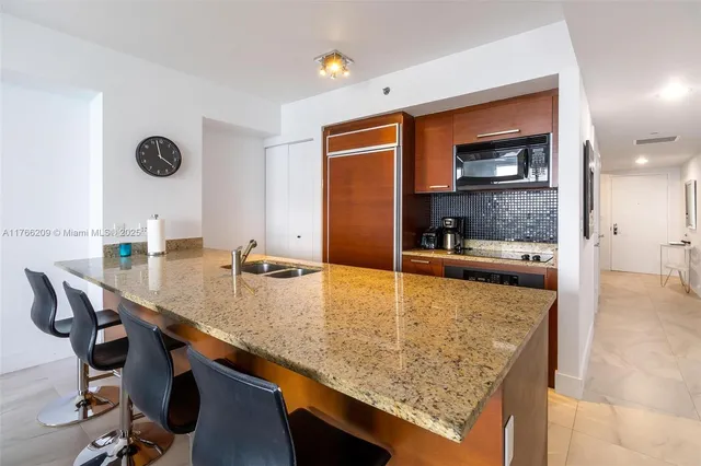 a kitchen with granite countertop a sink and a wooden floor