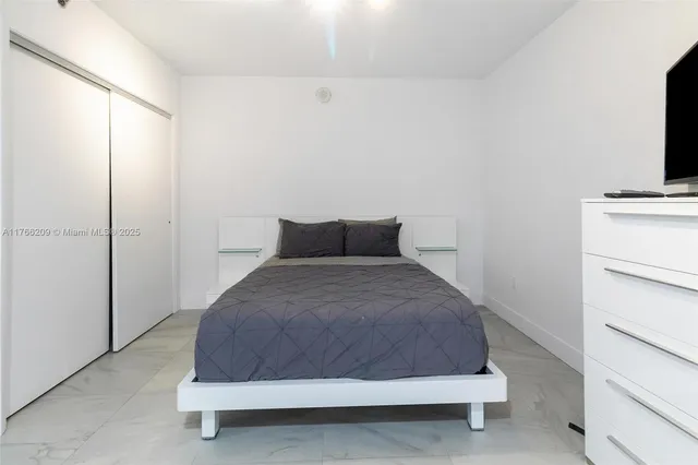 a bedroom with a bed and a flat screen tv