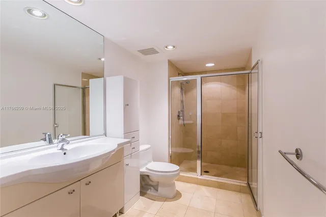 a bathroom with a double vanity sink toilet and shower