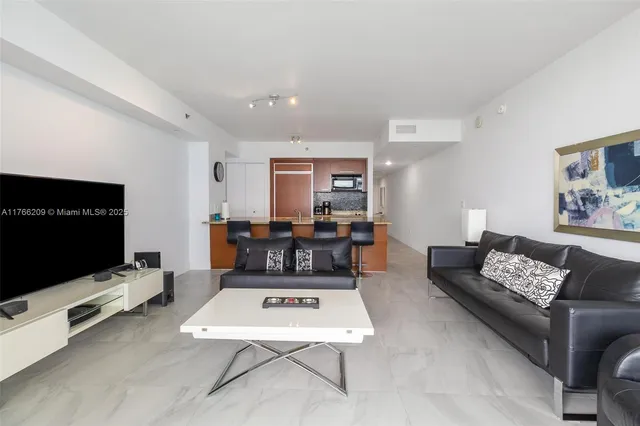 a living room with furniture a flat screen tv and paintings on the wall