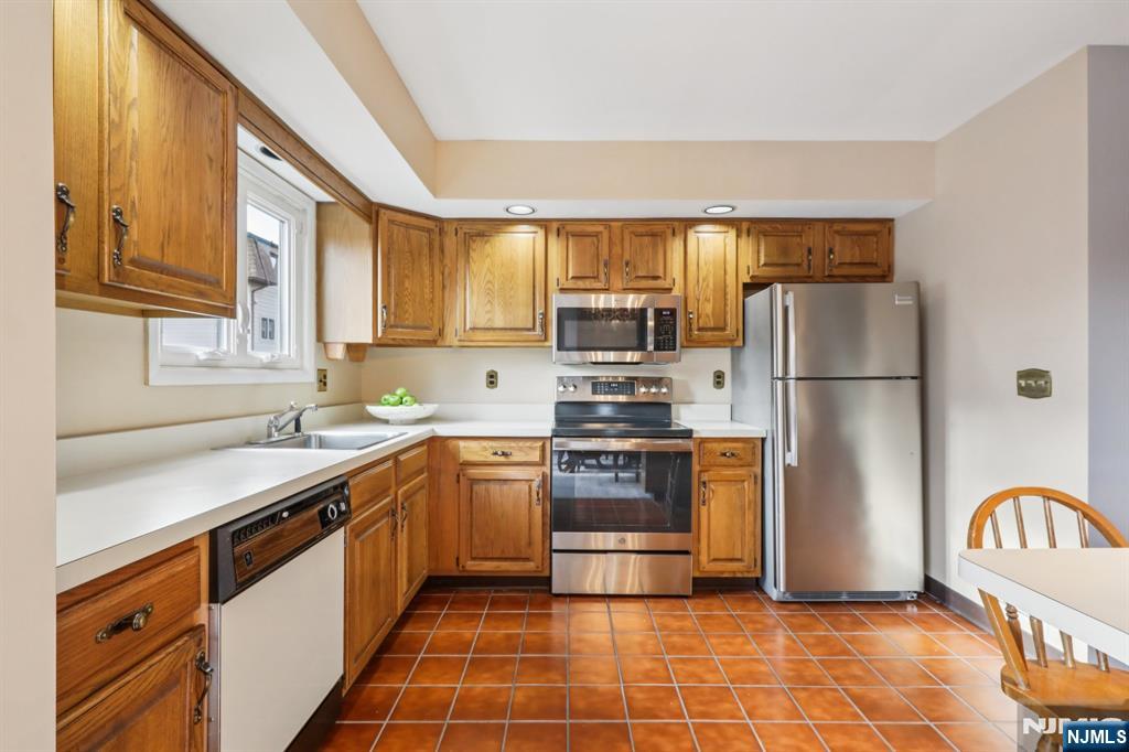 70 River Road, Unit C003 Clifton, NJ 07014 - Photo 13 of 35 a kitchen with stainless steel appliances granite countertop a refrigerator a stove a sink and a microwave