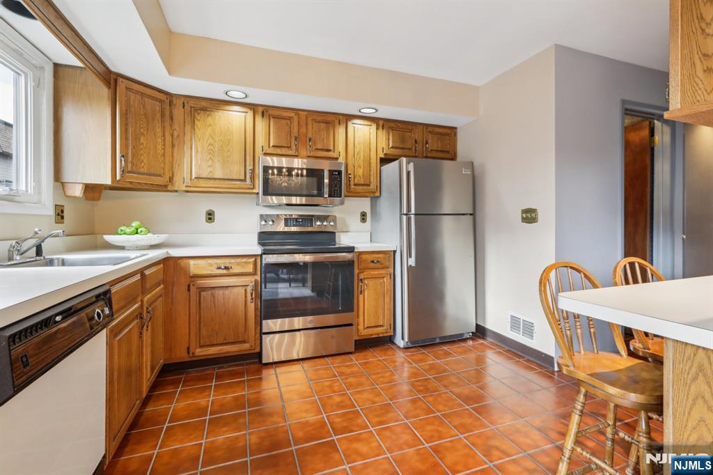 70 River Road, Unit C003 Clifton, NJ 07014 - Photo 16 of 35 a kitchen with stainless steel appliances a stove a sink and a refrigerator