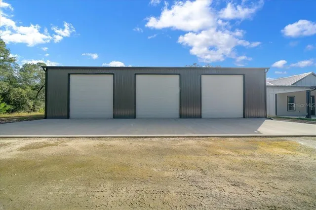a view of a house with a yard and large tree