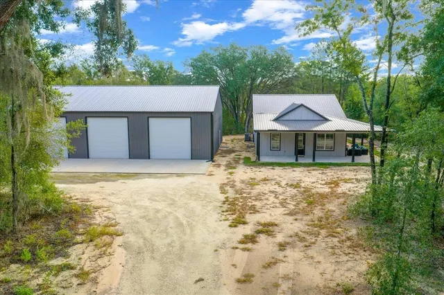 an aerial view of residential houses with outdoor space and trees