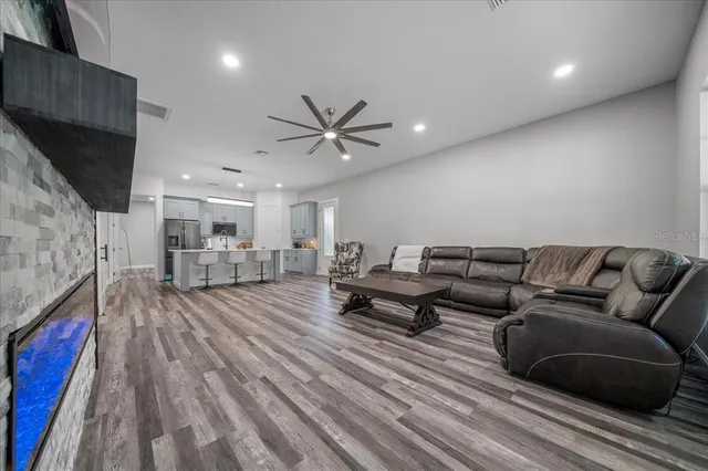 a kitchen with kitchen island granite countertop a sink cabinets and wooden floor